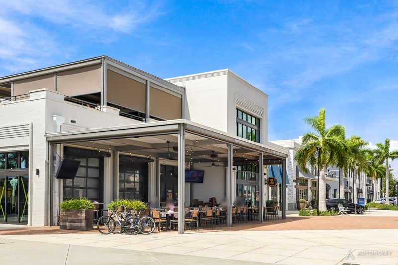 Covered restaurant patio with outdoor tables and bikes parked outside in Downtown Wellen