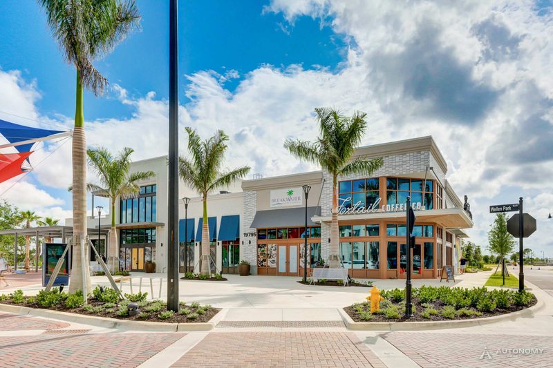 Two-story shop buildings with palms and a brick plaza in Downtown Wellen, Wellen Park