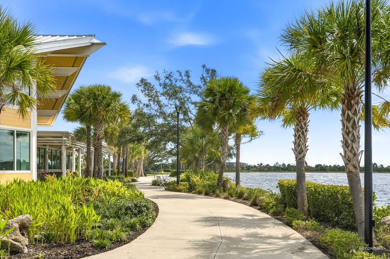 Curving paved lakeside path lined with palms and landscaping beside the Grand Lake, Wellen Park